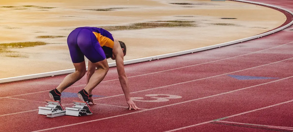 An athlete in the set position on a running track