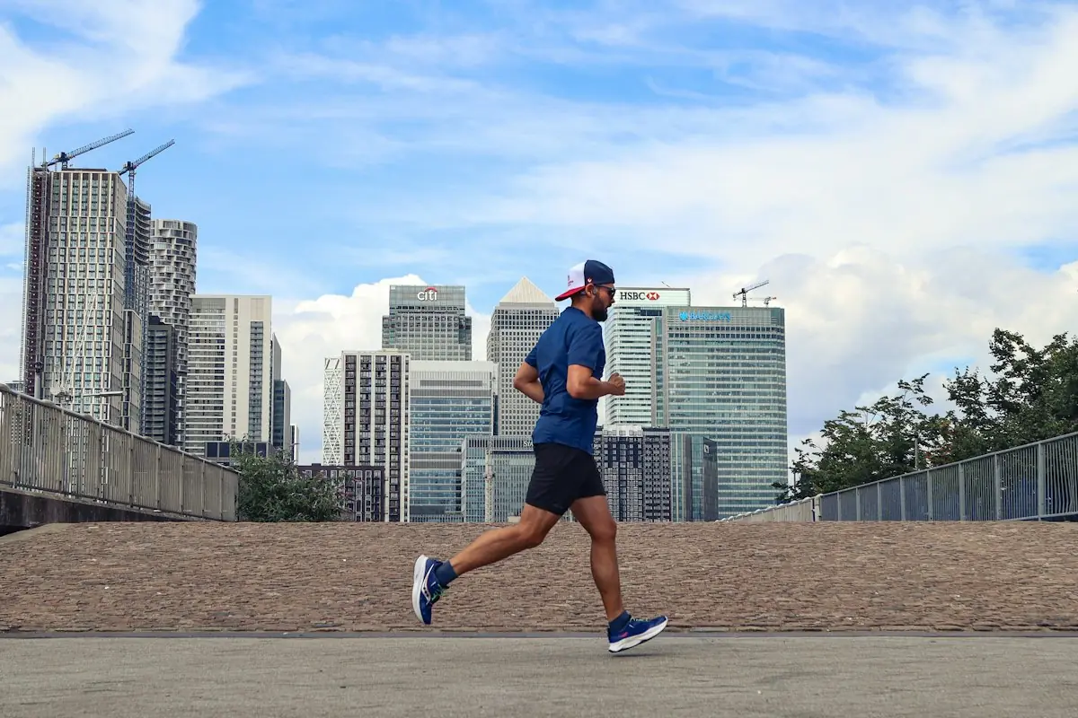 A man in his forties running past city buildings in the morning